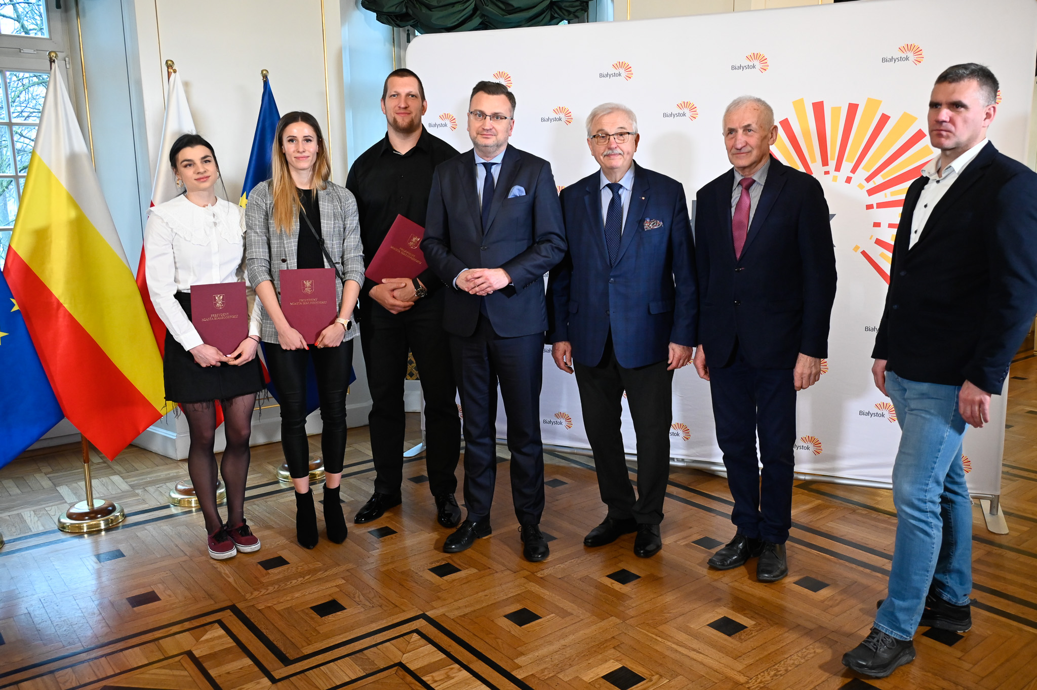 Dwie kobiety i czterech mężczyzn stoi obok siebie