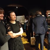 Ludzie oglądają wystawę w muzeum, rozmawiają ze sobą