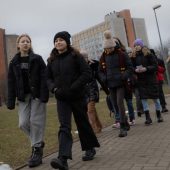Grupa uczniów idzie chodnikiem na kampusie