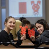 Uczennice pokazują wycięte z papieru chiński znaka królika