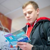 Młody mężczyzna czyta ulotkę.