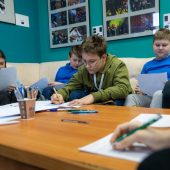 Grupa uczniów w studiu radia piszą na kartkach