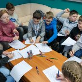Grupa uczniów w studiu radia piszą na kartkach