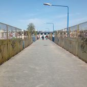 Ludzie idą po kładce nad torami