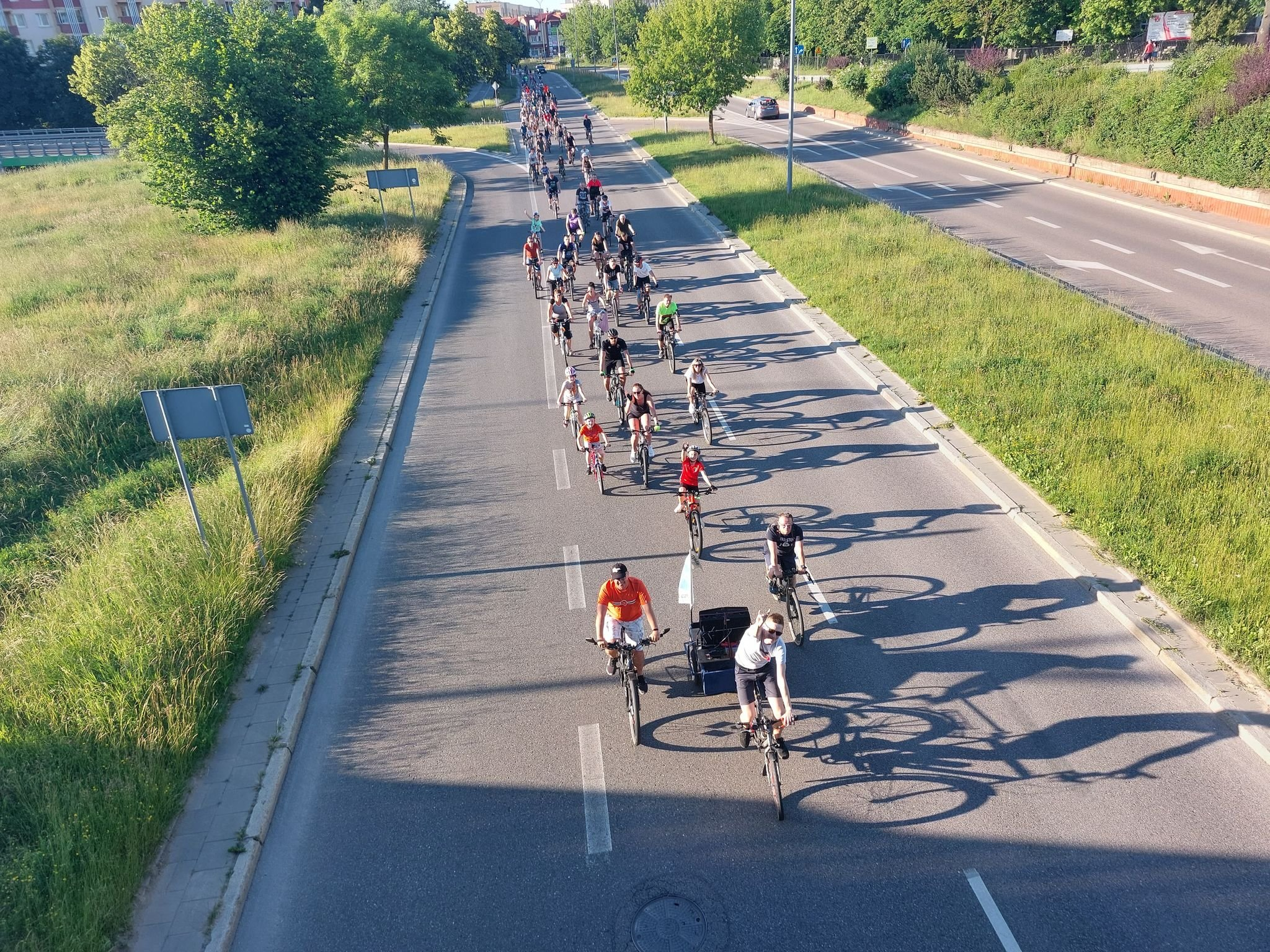 Widok z lotu ptaka na dużą grupę rowerzystów.