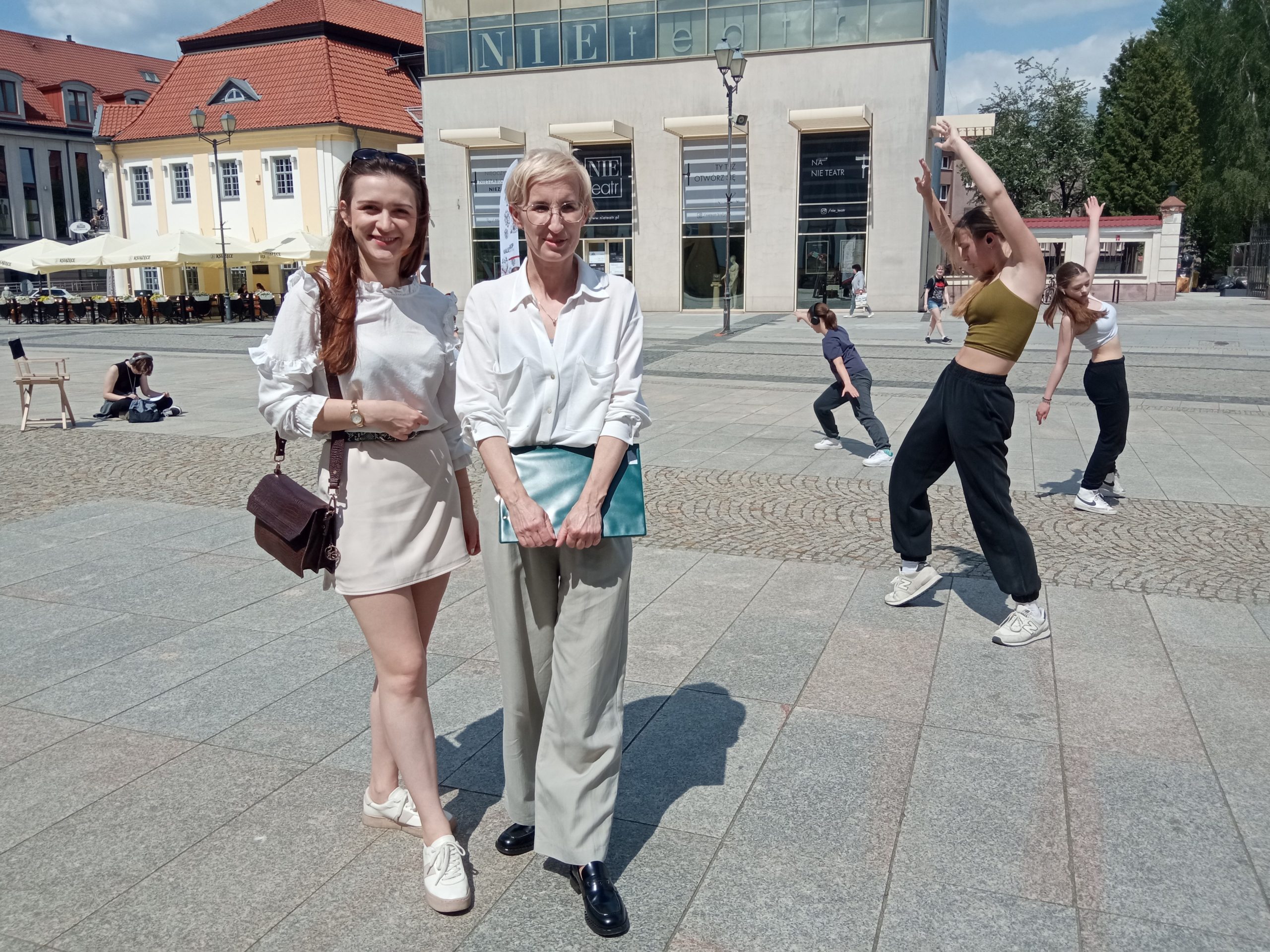 Dwie kobiety stoją na tle tańczących dziewcząt