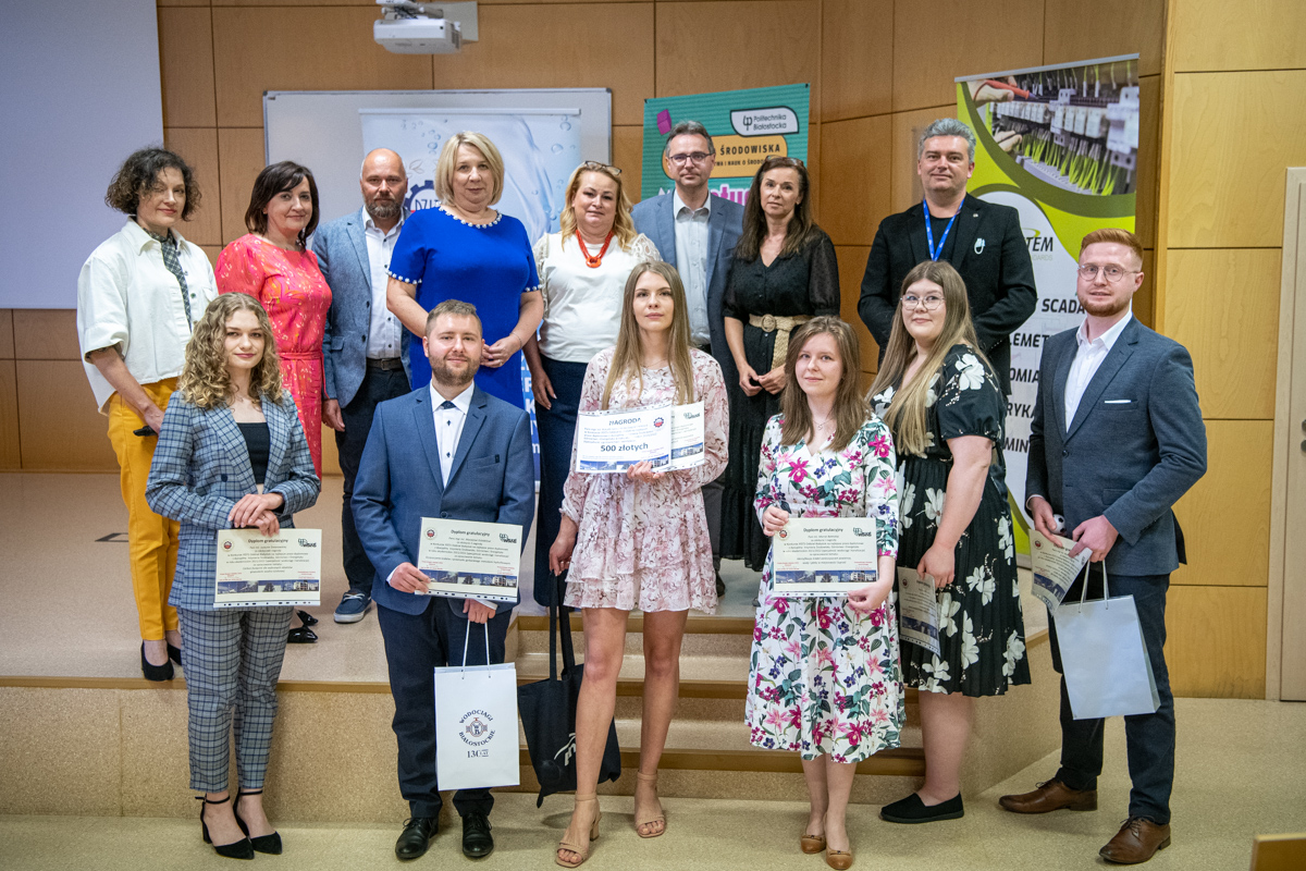 Nagrodzone osoby stoją z przodu trzymają dyplomy, z tyłu stoją promoorzy i przedstawiciele firm
