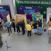 Ludzie stoją przy maszynach własnych konstrukcji.