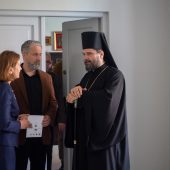 Konbieta, mężczyzna i prawosławny duchowny rozmawiają.