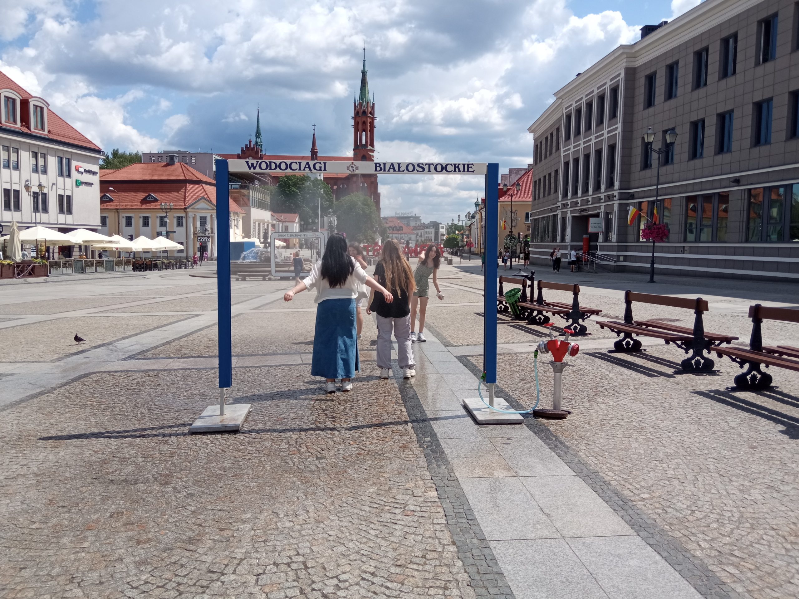 Kobiety przechodzą przez mgiełkę kurtyny wodnej