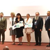 Ludzie trzymają symboliczne czeki.