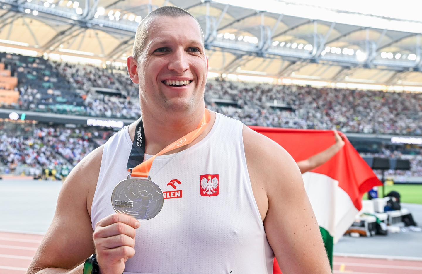 Mężczyzna trzyma srebrny medal.