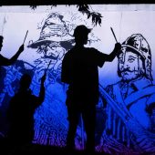 Dwie osoby malują mural.