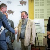 Mężczyzna z brodą ściska dłoń wysokiemu mężczyźnie