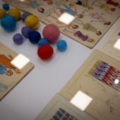 Rysunki projektowe ubrań i kłębki włóczki leżą na stole