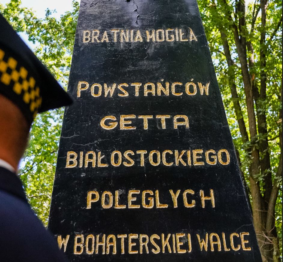 Fragment napisu złote litery na czarnym kamieniu na pomniku
