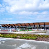 Nowe wiaty, rabaty kwiatowe, w tle autobus na przystanku