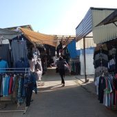 Kobieta idzie pomiędzy straganami na bazarze