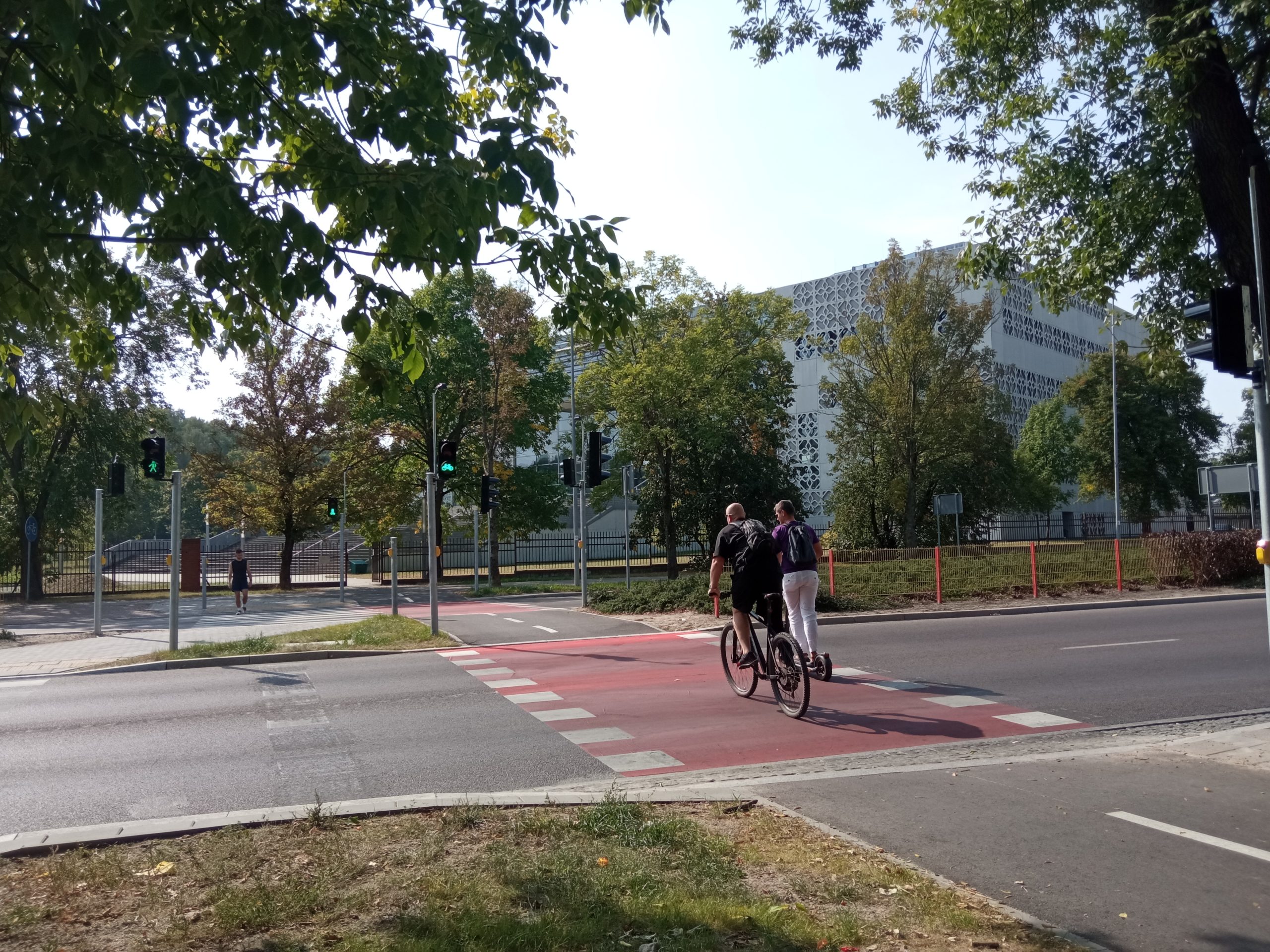 Rowerzysta i mężczyzna na hulajnodze przejeżdżają przez przejście