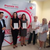 Kilka osób stoin obok siebie podczas konferencji