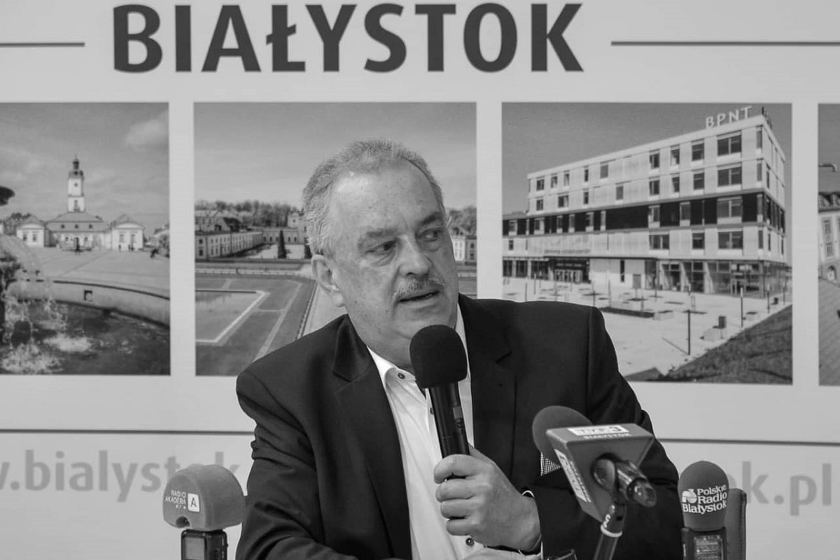 Mężczyzna siedzi na krześle, w ręce trzyma mikrofon