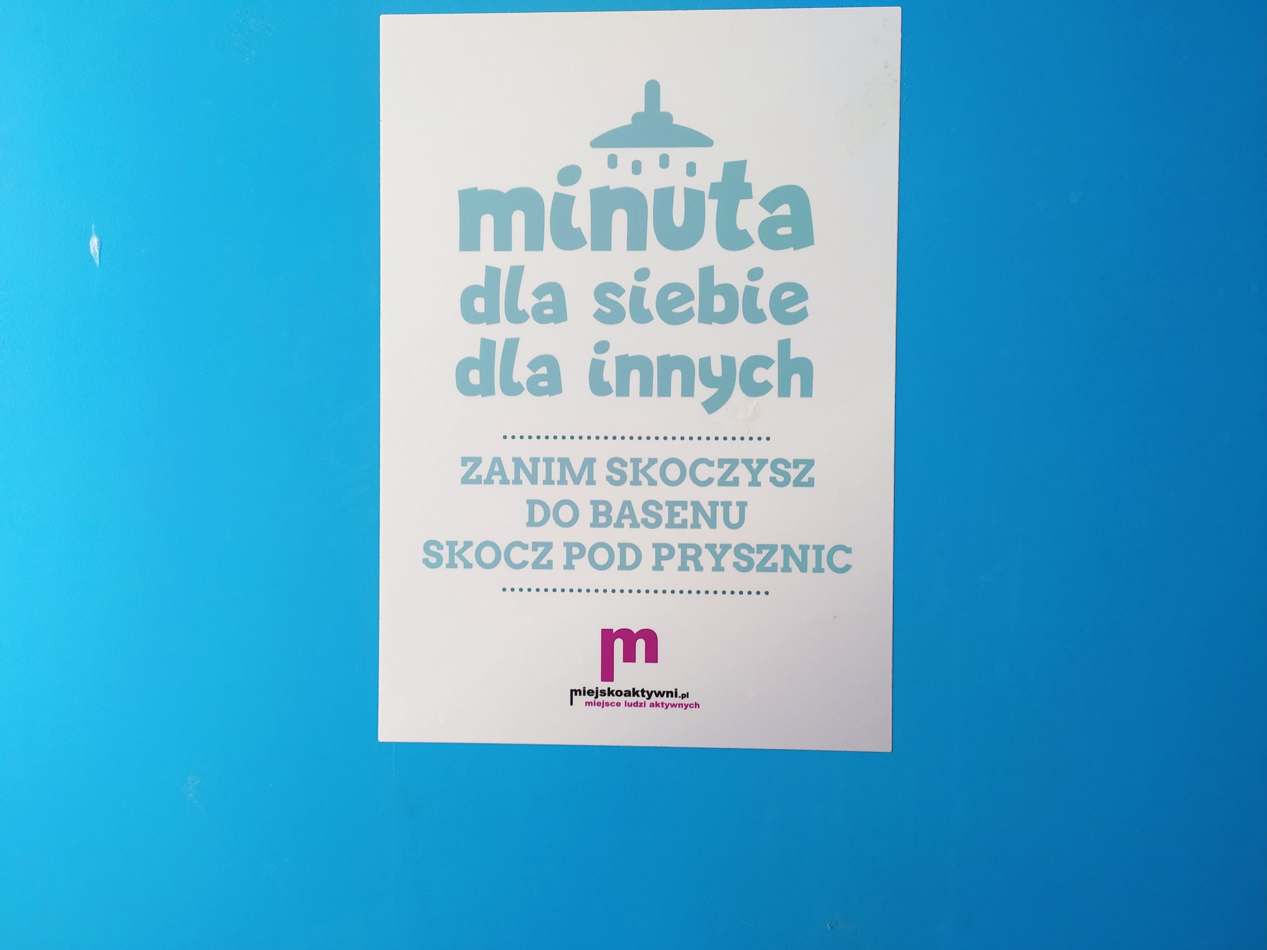Kartka z napisem akcji wisi na niebieskim tle.