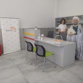 Dwie kobiety stoją w lokalu za biurkiem. Punkt Informacji turystycznej