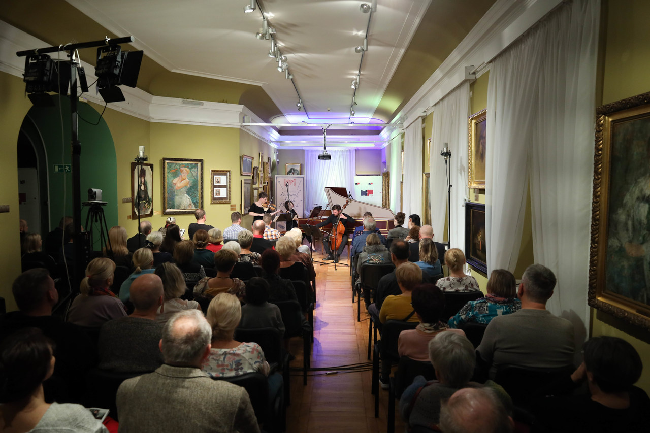 Ludzie w sali słuchają występu muzycznego