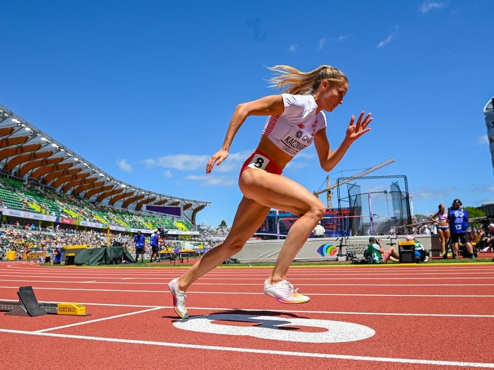 Biegaczka biegnie na stadionie.