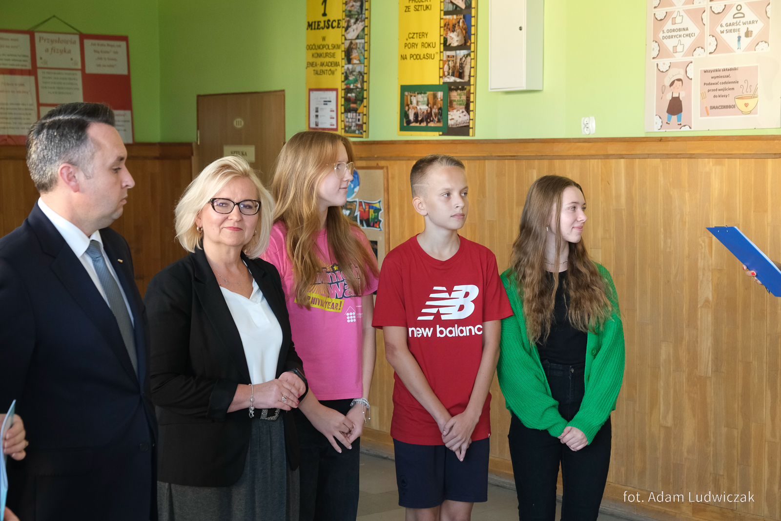 Mężczyna kobieta i troje uczniów stoi podczas konferencji