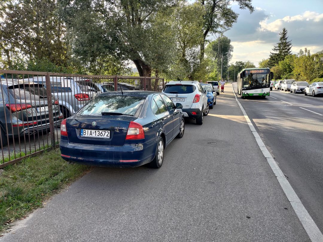 Samochody zaparkowane na ścieżce rowerowo-pieszej.