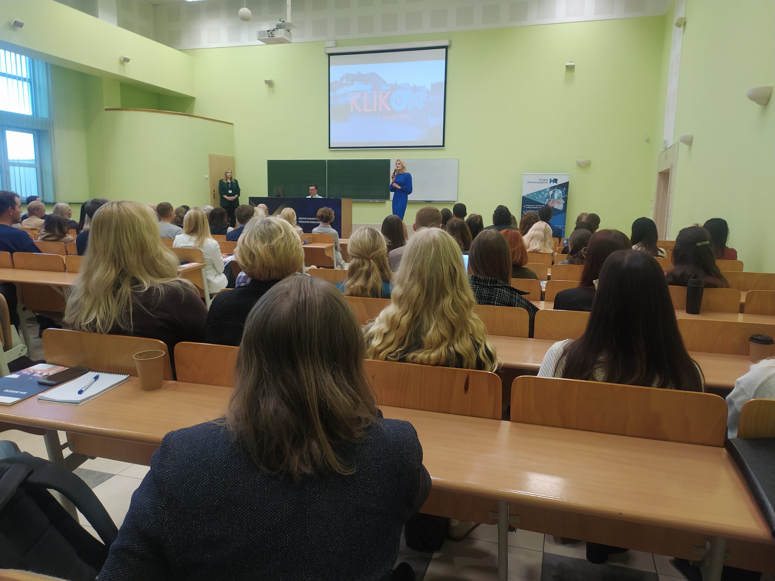 Ludzie siedzą w ławkach na konferencji
