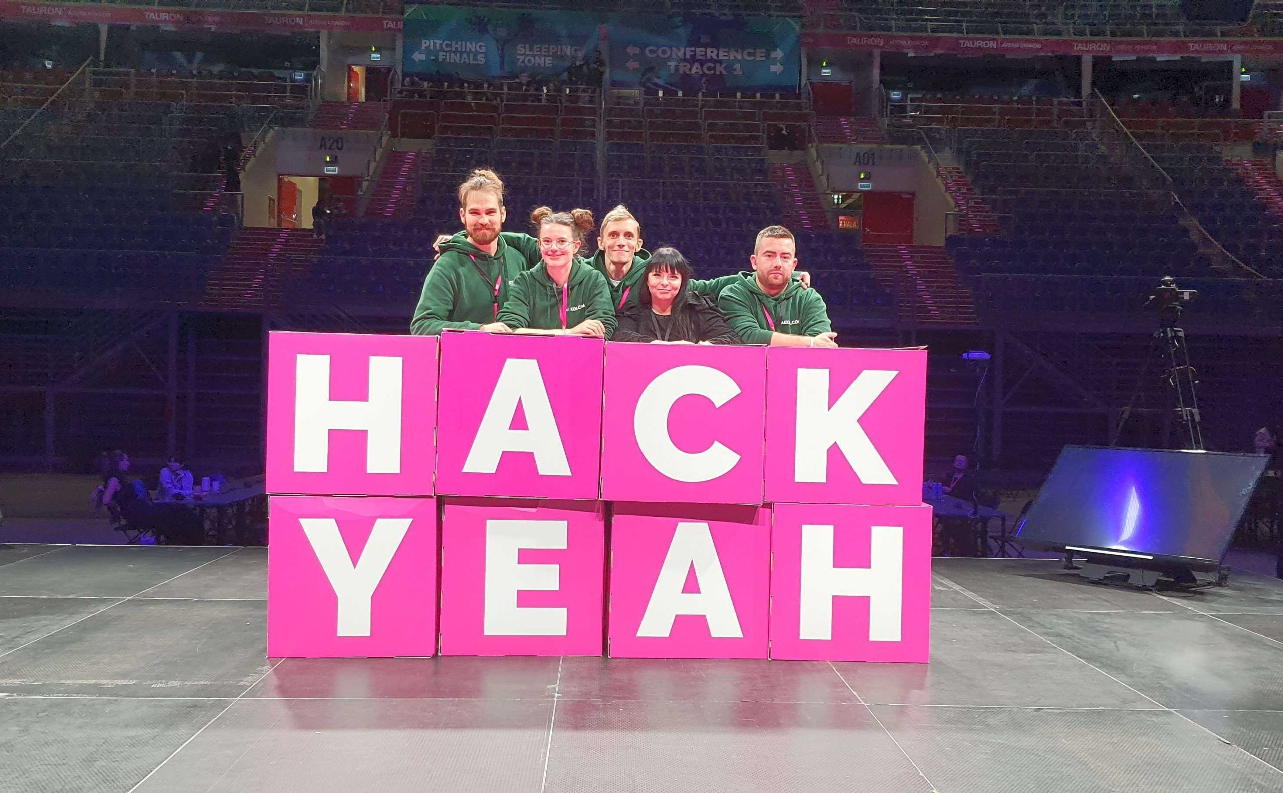 Pięć osób pozuje do zdjęcia przy napisie HACKYEAH.
