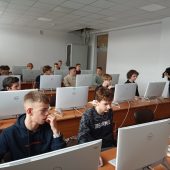 Ludzie siedzą przed komputerami.