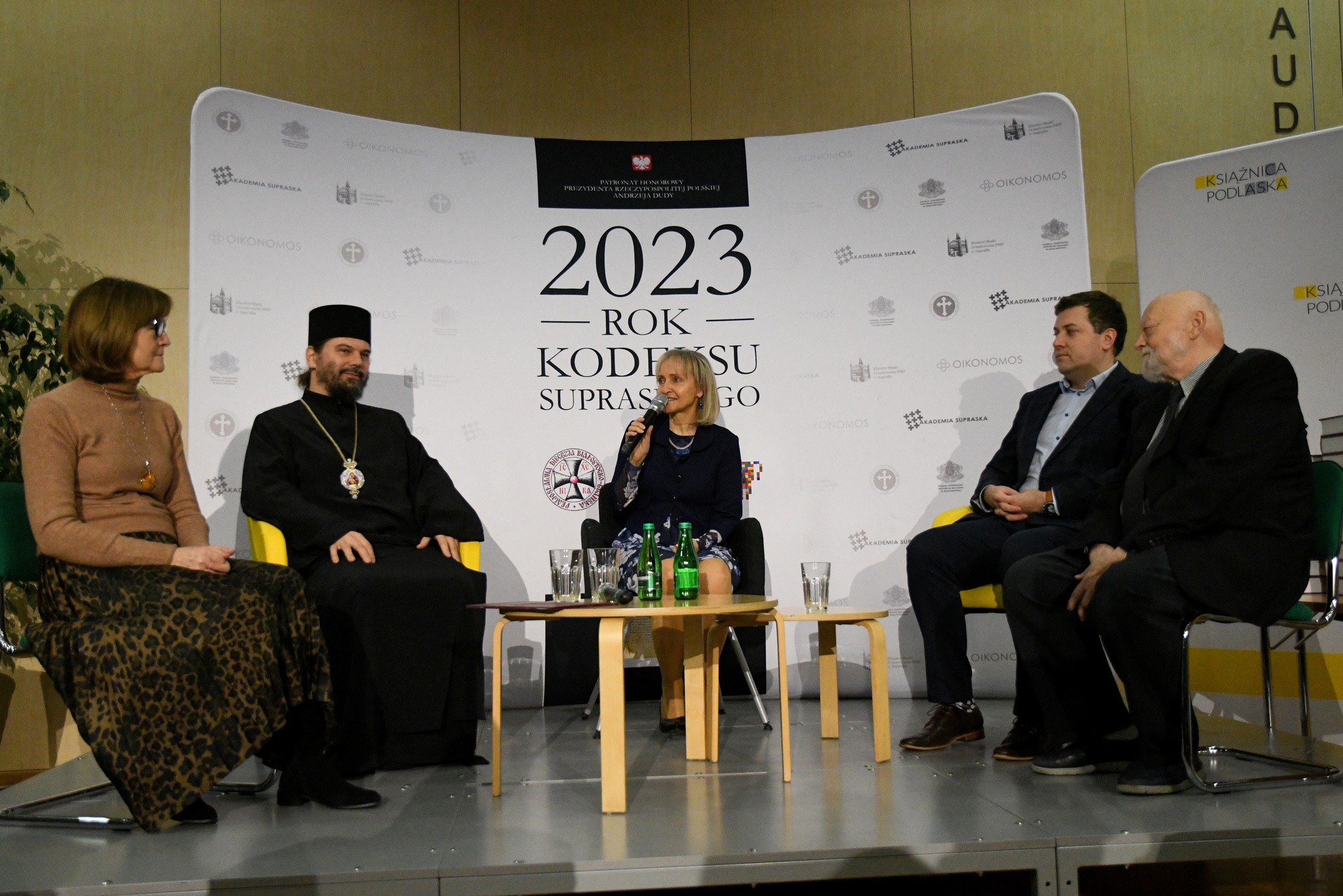 Ludzie siedzą wokół niskiego stolika.