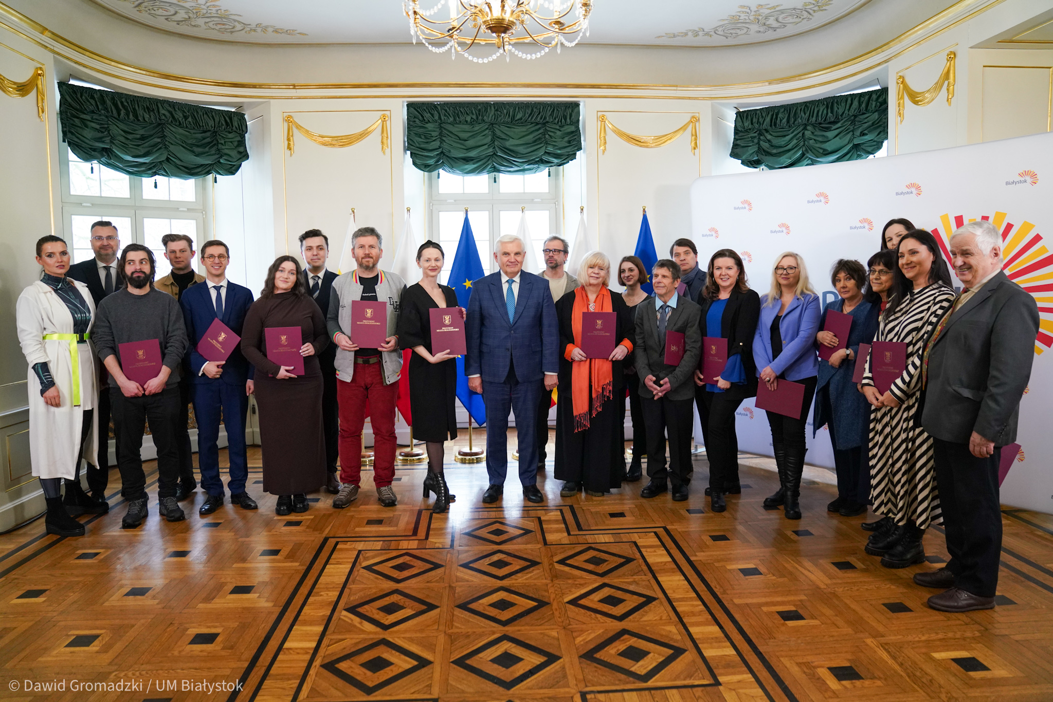 Ludzie pozują do zdjęcia z dyplomami.