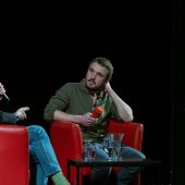 Mężczyzna w fotelu na scenie.