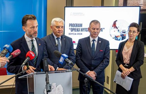 Ludzie w garniturach na konferencji prasowej.