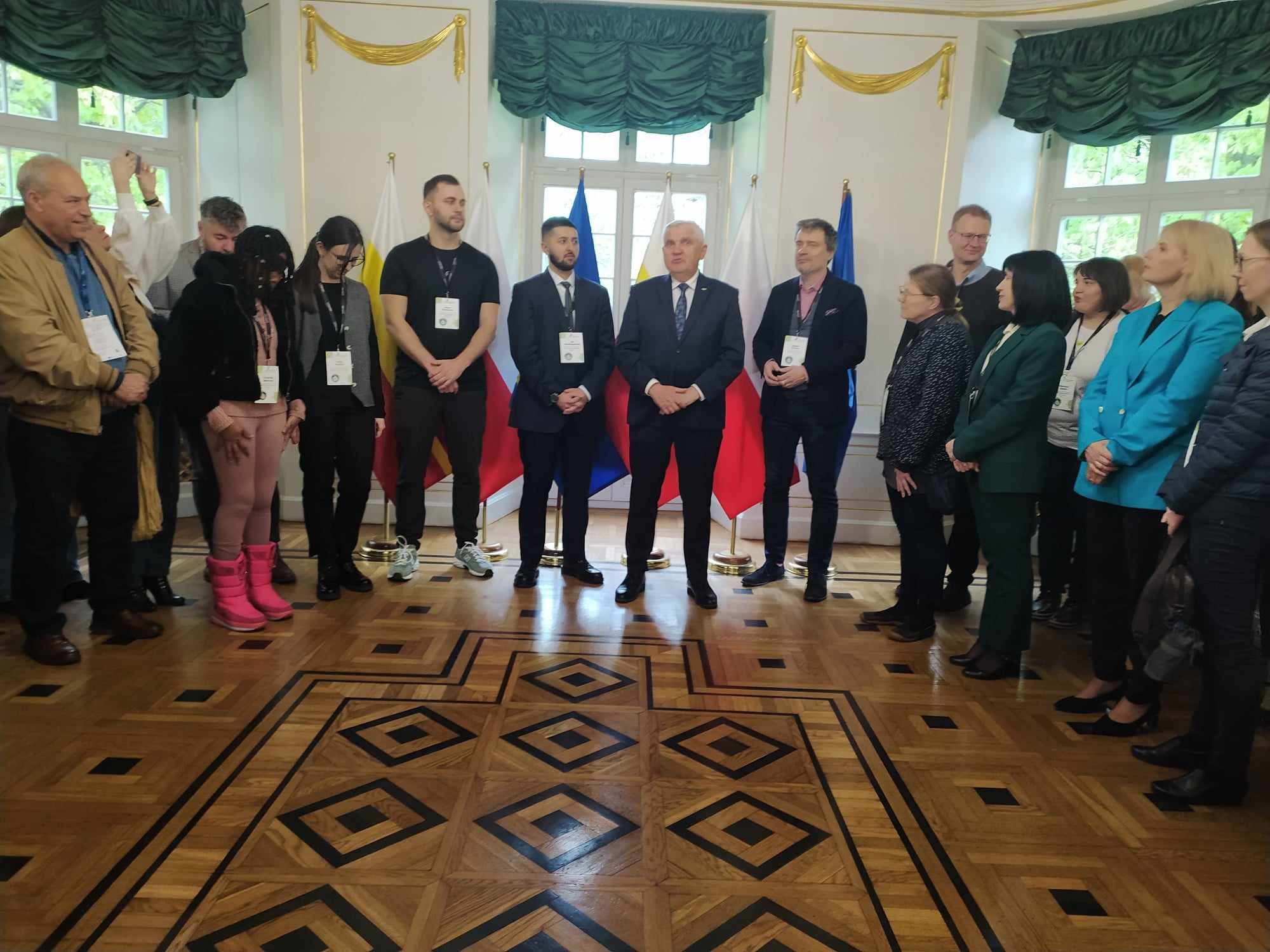 Międzynarodowe spotkanie ludzi w uroczystej sali.