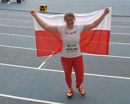 Zawodniczka trzyma na plecach flagę Polski