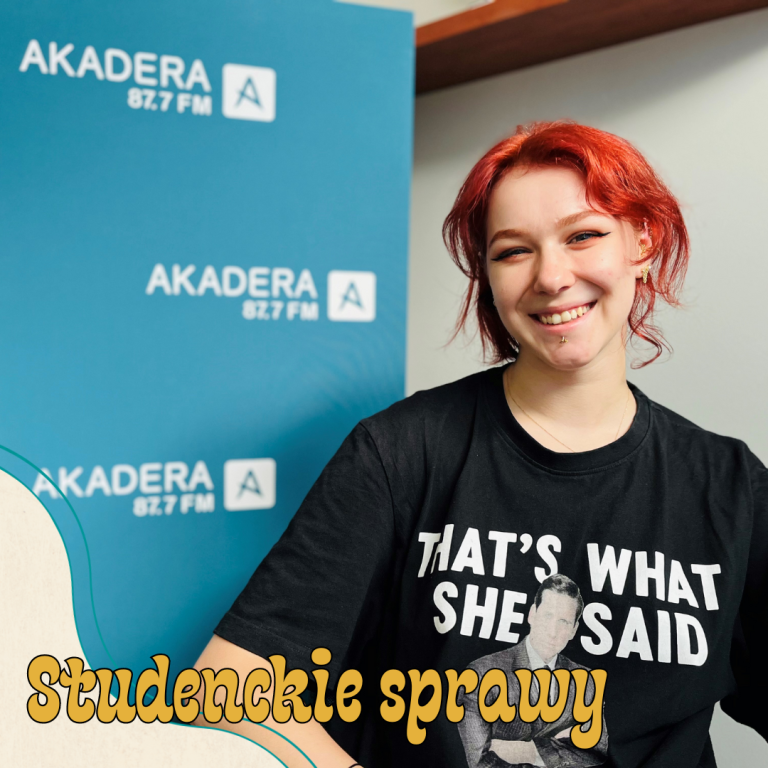 Młoda studentka uśmiecha się, ma czarną krótką koszulkę, czerwone włosy, siedzi na tle ścianki Radia AKadera