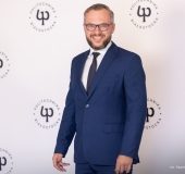 Mężczyzna na ściance firmowej.