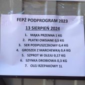 Kartka z informacjami wiszą na blasze budynku.