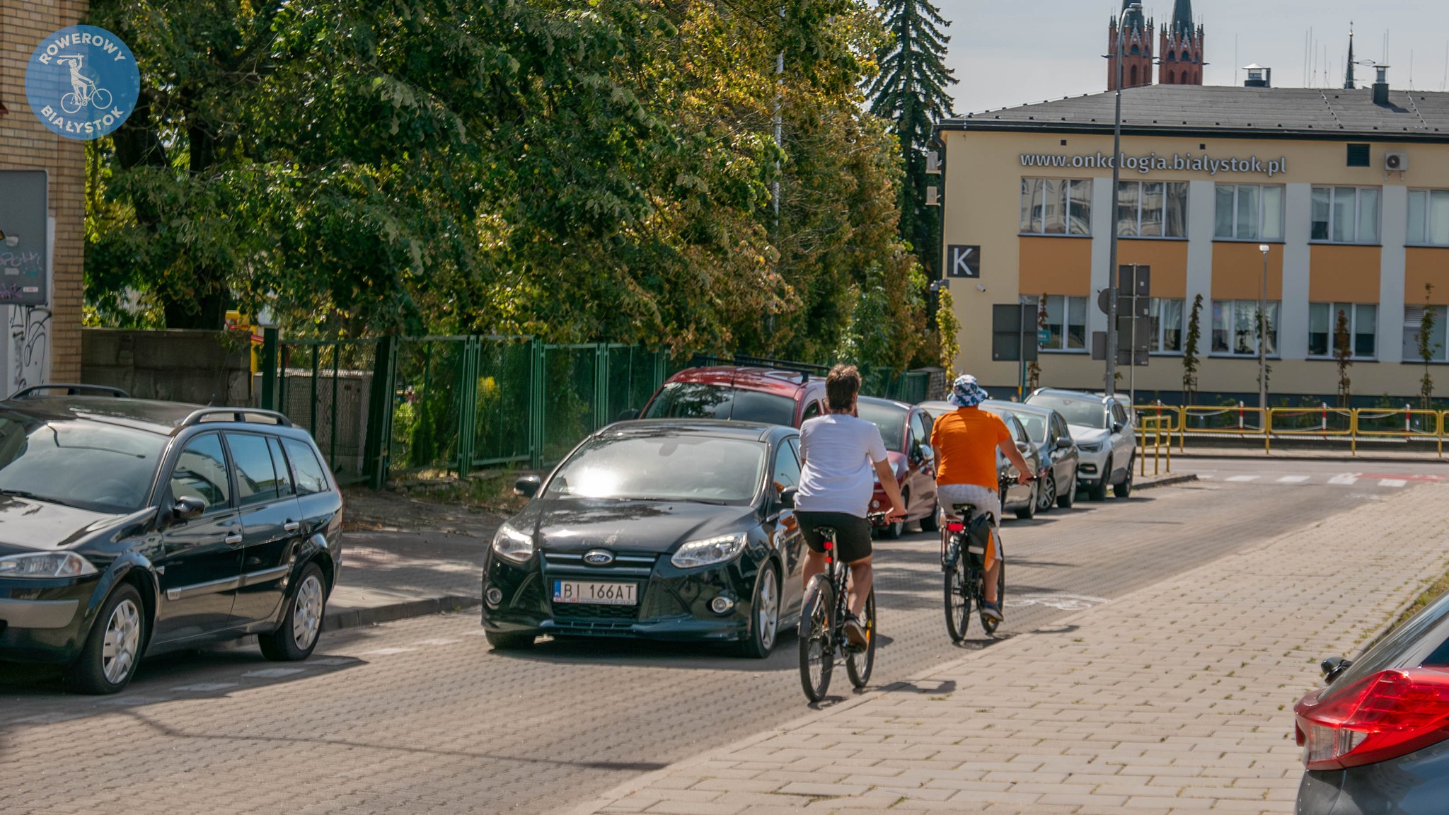 Rowerzyście jadą kontraruchem po ulicy.