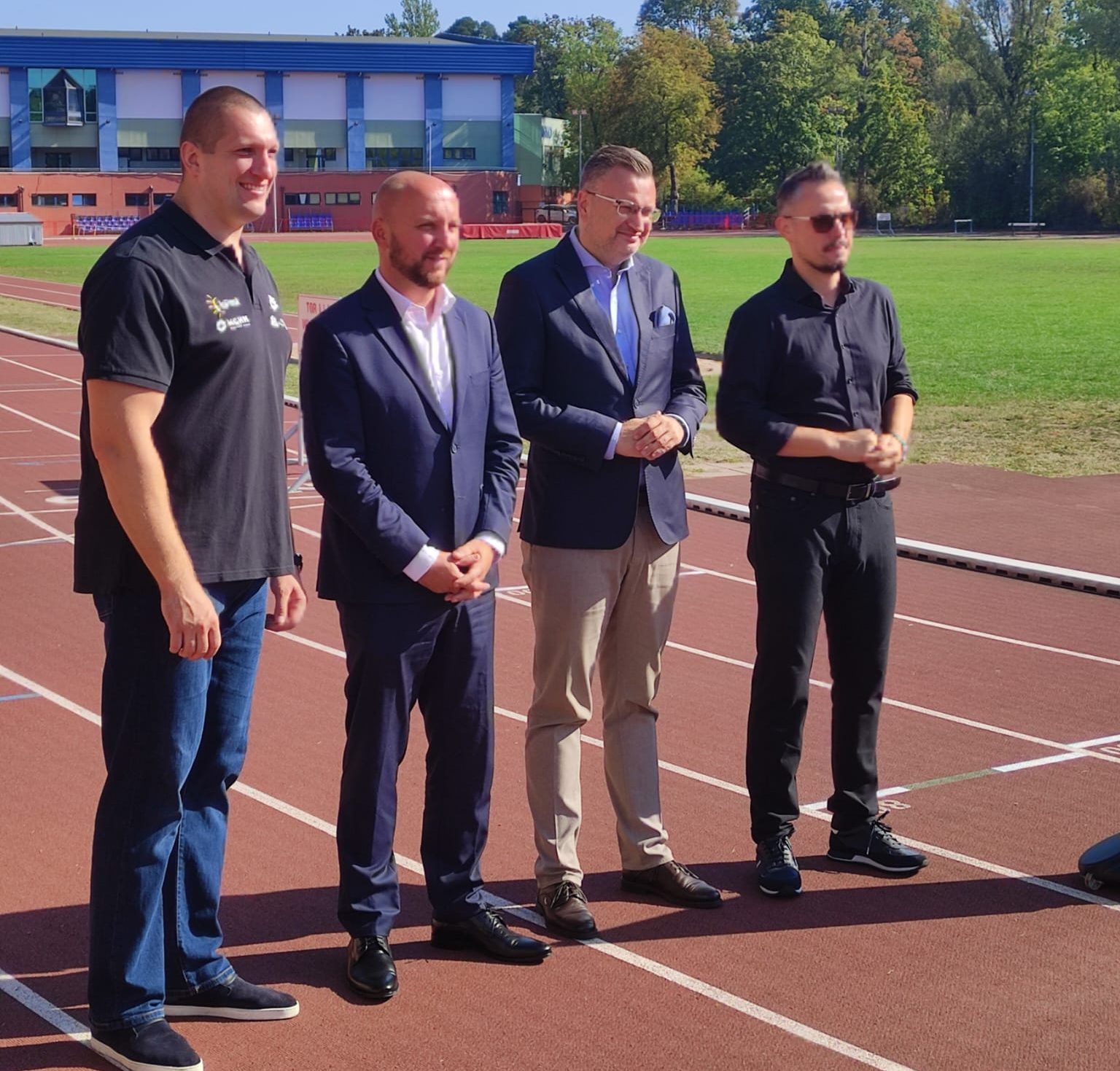 Na murawie Białostockiego Stadionu Zwierzyniec stoją uczestnicy Briefingu Prasowego.