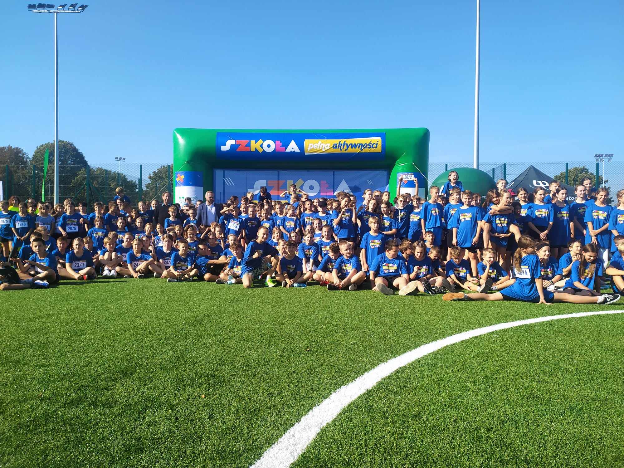 Dzieci na sportowe ubrane pozują do zdjęcia.