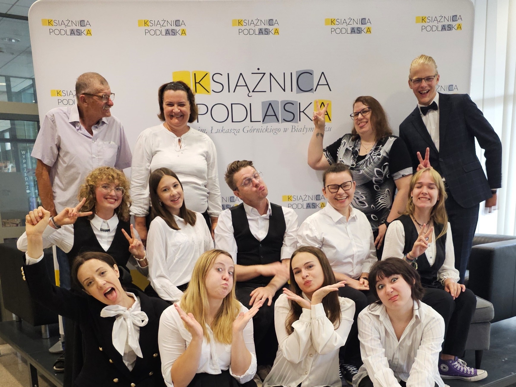 Ludzie ubrani na galowo pozują do zdjęcia.