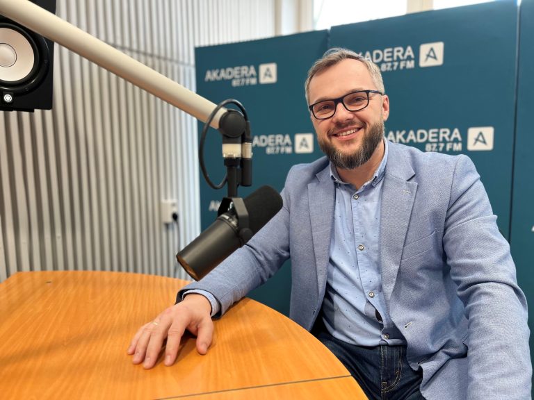 uśmiechnięty mężczyzna w średnim wieku, w okularach jasnej marynarce siwy
