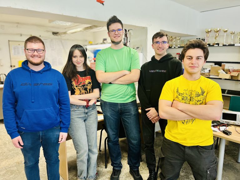 Pięcioro studentów Politechniki Białostockiej z zespołu SumoMasters pozuje w pracowni robotyki.