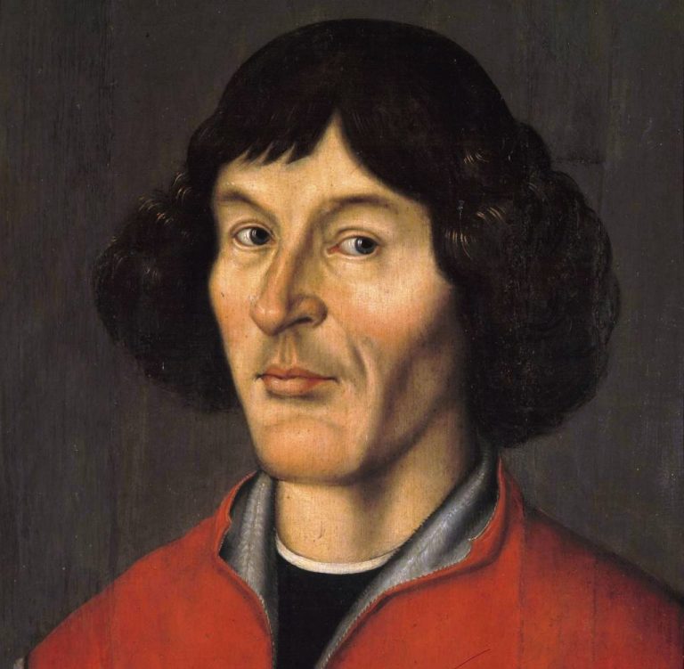 Portret Mikołaja Kopernika przedstawiający mężczyznę o ciemnych, półdługich włosach i skupionym spojrzeniu. Ubrany jest w czerwoną szatę z szarym kołnierzem. Tło jest ciemne, neutralne, co podkreśla wyrazistość twarzy i powagę postaci. Obraz ukazuje Kopernika jako uczonego, którego myśl naukowa zrewolucjonizowała świat.